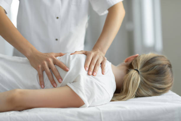 Chiropractor performing a spinal adjustment in a well-lit clinic