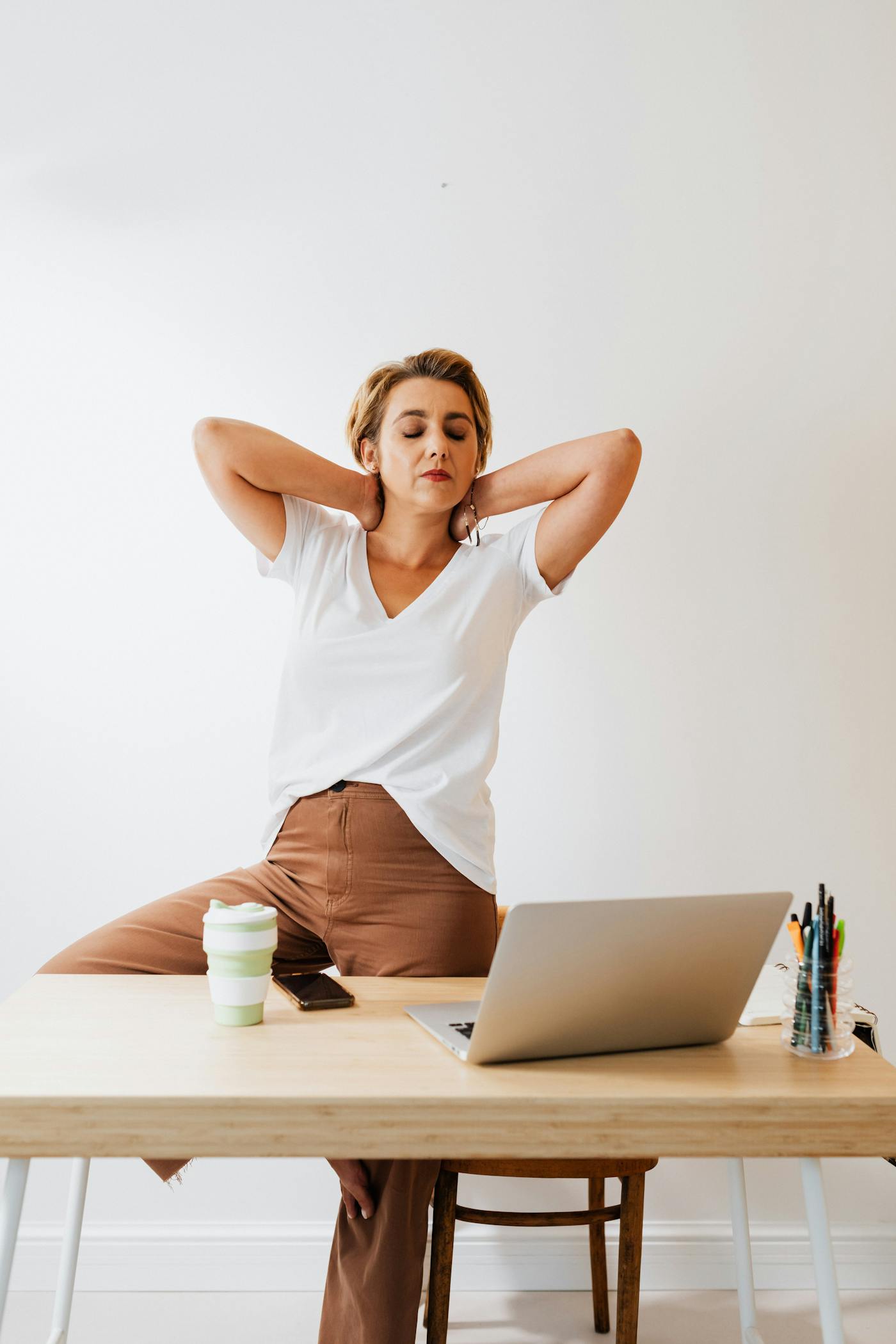 Office worker taking a wellness stretch break at her desk